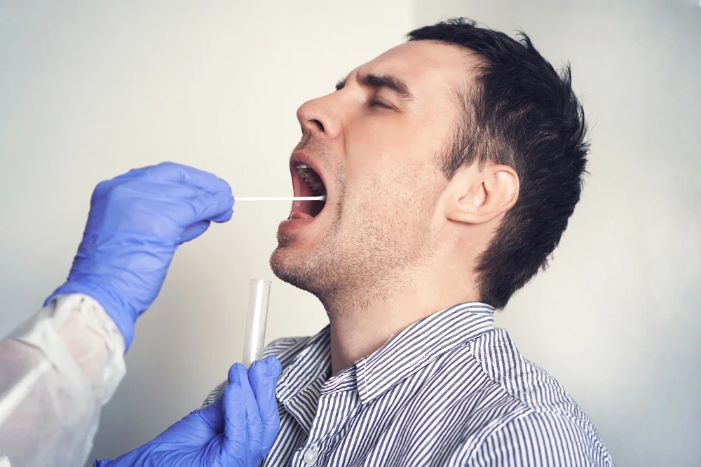 DNA test. Doctor Doing Coronavirus covid 19 Test For male Patient. Taking a saliva sample from a man. Collection of mucus from the throat for research in the laboratory.