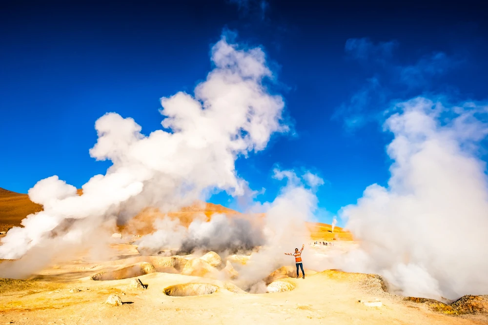 Girl near steaming geysers in Bolivia